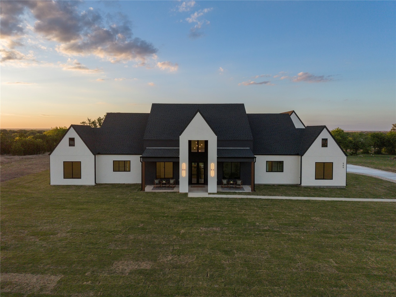 The elegant interior of a luxury Liberty Hill home showing a gourmet kitchen with quartz countertops and a massive island overlooking an open-concept living area with large windows